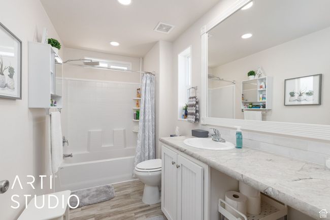 Bathroom with wood finished floors, vanity, shower / bath combo with shower curtain, and recessed lighting | Image 20