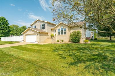 View of front facade with a garage and a front lawn | Image 2