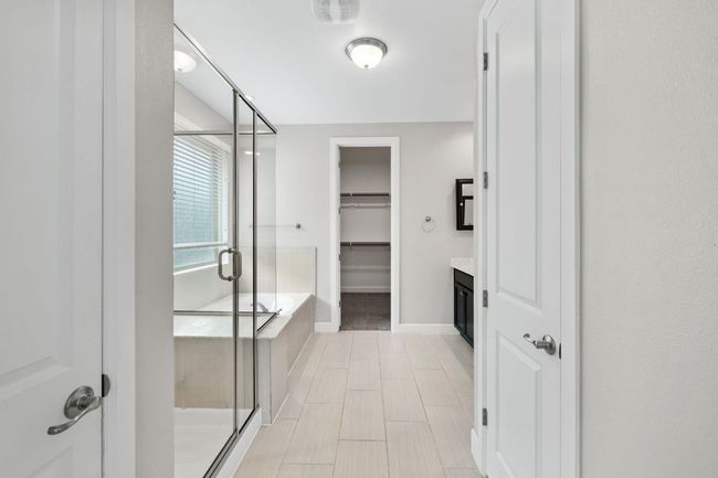Bathroom with vanity, a bath, a stall shower, baseboards, and a spacious closet | Image 21