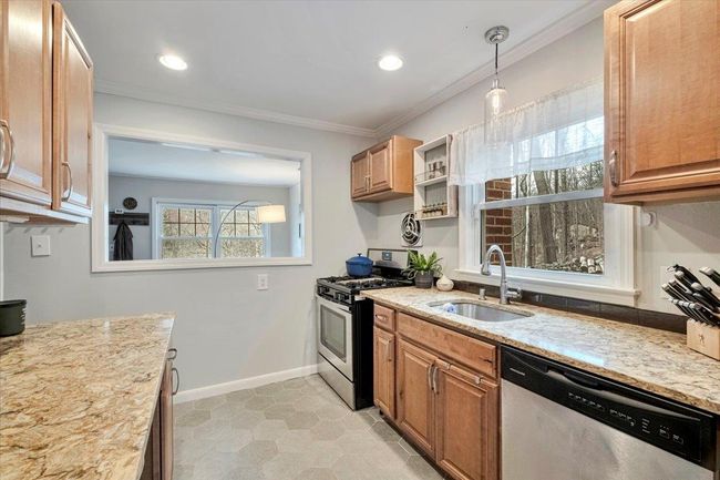 Kitchen with ornamental molding, baseboards, a sink, light stone countertops, and appliances with stainless steel finishes | Image 4