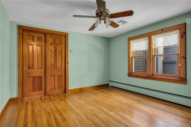 Bedroom #2 has a large window overlooking the yard, a double closet and ceiling fan. | Image 18