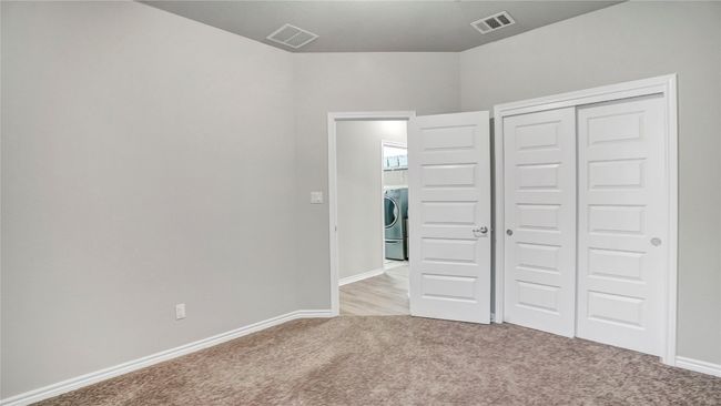 Unfurnished bedroom with washer / clothes dryer, visible vents, baseboards, a closet, and light carpet | Image 24