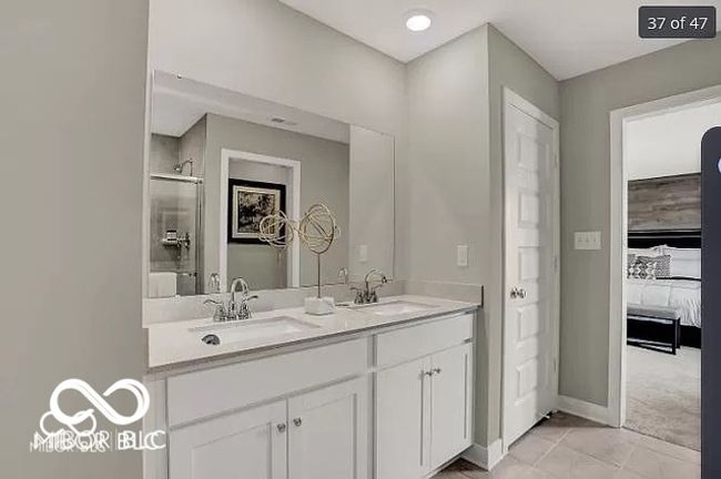 Primary bathroom with a shower with shower door, baseboards and double sinks | Image 17
