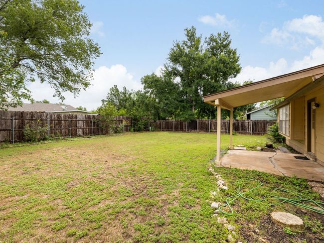 Fenced backyard with a patio | Image 19