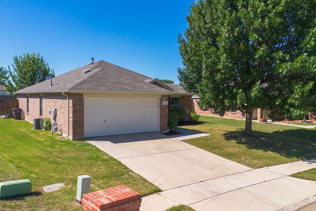 View of front facade with a front lawn, brick siding, concrete driveway, and a garage | Image 4
