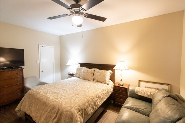 Bedroom with wood finished floors and a ceiling fan | Image 7