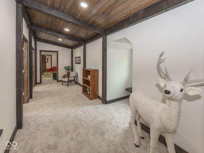 sitting room featuring wooden ceiling, light colored carpet, baseboards, recessed lighting, and arched walkways | Image 30