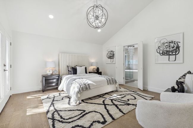 Bedroom featuring a notable chandelier, wood finished floors, and baseboards | Image 20