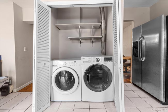 Laundry room with light tile patterned floors and washing machine and clothes dryer | Image 4