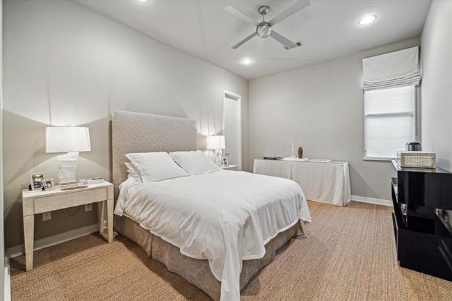 BEDROOM #2 - this one grass cloth flooring, painted walls, base molding, ceiling fan, recessed lighting, window with Roman shade, walk-in closet with hanging compartments/built-in shelving and shared bath with another Guest Bedroom. | Image 32