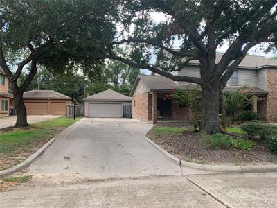 Plenty of room to park in this extra wide driveway leading to a huge 4 car garage. This garage can hold 4 cars easily or provide ample storage. Back half is currently partitioned off for storage accessible from a side door in back. | Image 2