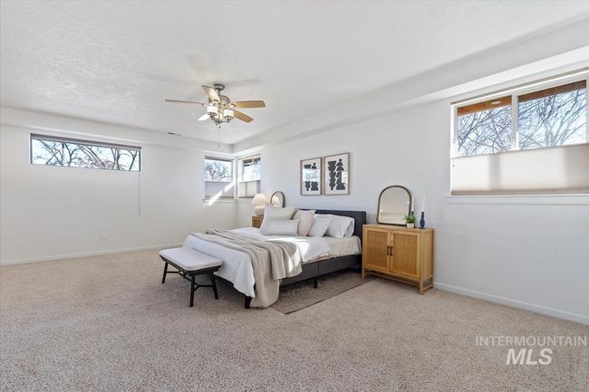 Bedroom featuring light colored carpet, ceiling fan, and a textured ceiling | Image 28