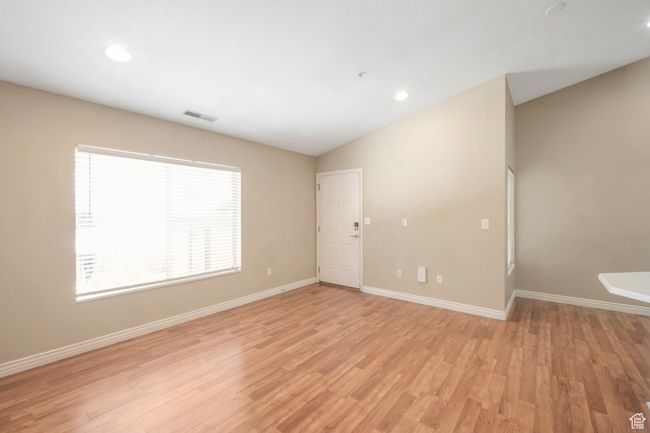 Empty room featuring lofted ceiling, light wood-style floors, and recessed lighting | Image 7