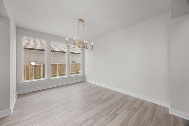 Unfurnished dining area with a chandelier, light wood finished floors, and baseboards | Image 13