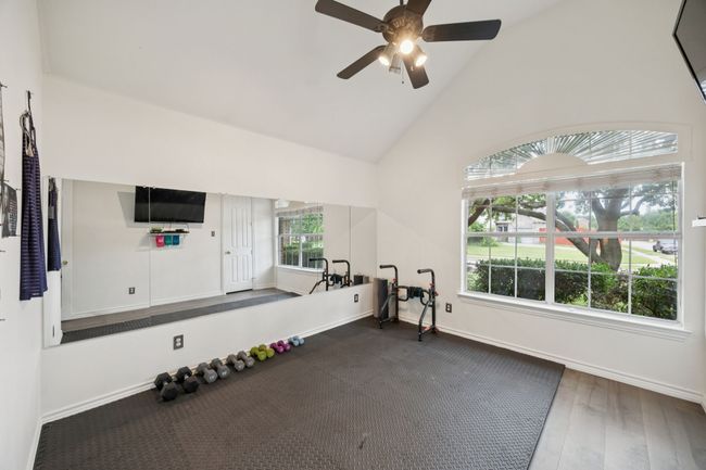 Currently used as a home gym, this flex space features mirrored walls and large windows—easily convertible to a fourth bedroom, studio, or second office. | Image 24