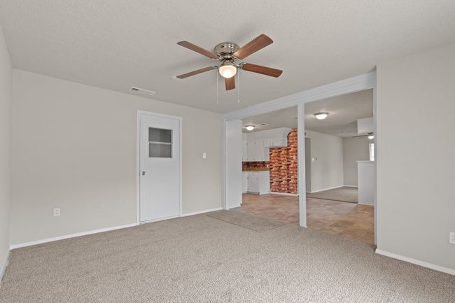 Unfurnished living room featuring carpet, ceiling fan, and a textured ceiling | Image 11