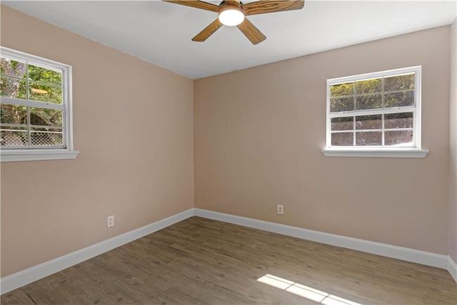 Unfurnished room featuring ceiling fan, baseboards, and wood finished floors | Image 17