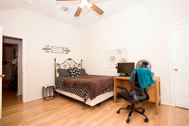 Bedroom featuring light wood-style flooring, a ceiling fan, and vaulted ceiling | Image 13