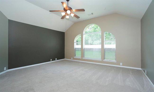 A serene primary suite with recent carpet, vaulted ceiling and lovely backyard views. | Image 18