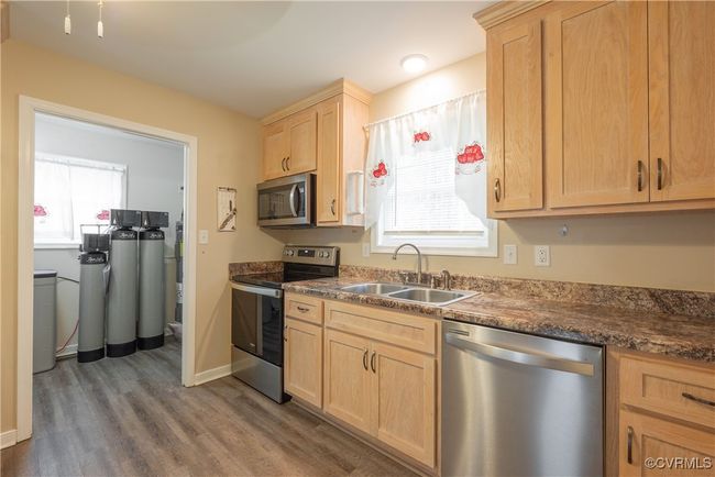 Kitchen with a sink, wood finished floors, light brown cabinetry, stainless steel appliances, and baseboards | Image 10