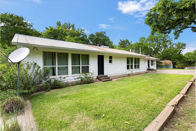 Ranch-style house featuring entry steps, a front lawn, and brick siding | Image 17