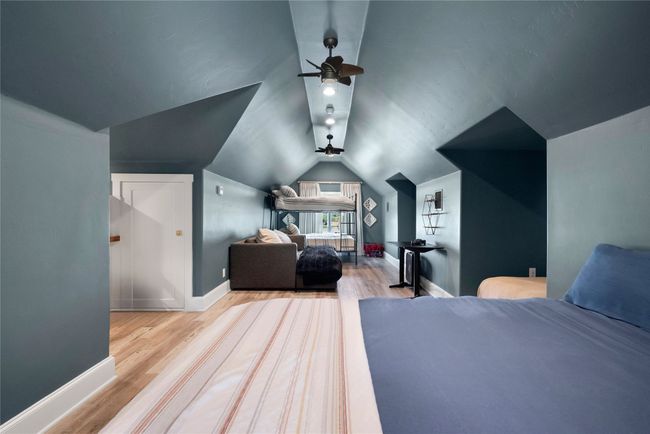 Bedroom with wood finished floors and lofted ceiling | Image 16