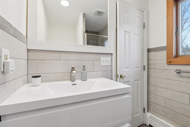 Full bathroom featuring vanity, visible vents, a walk in shower, wood walls, and baseboard heating | Image 22