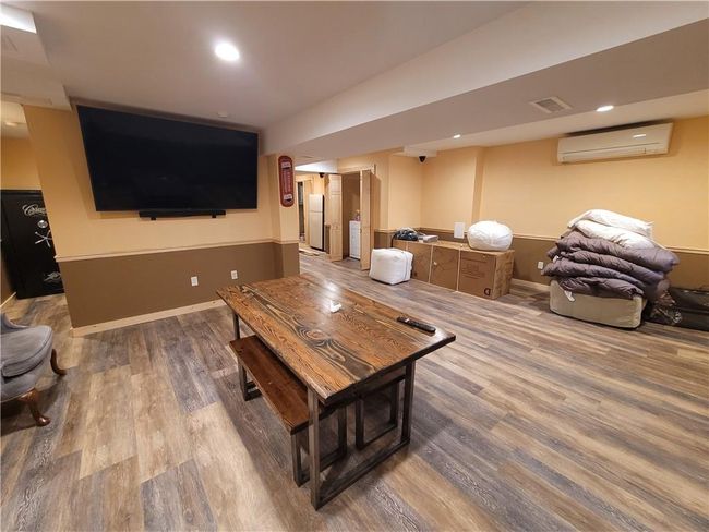 Living room with hardwood / wood-style floors and an AC wall unit | Image 16