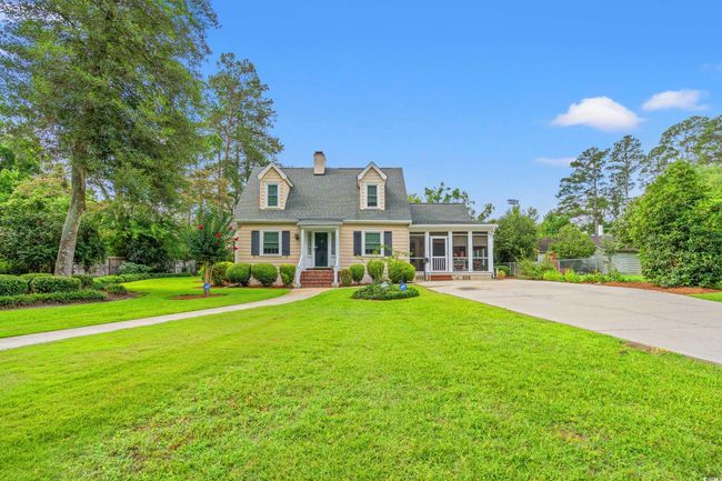 Cape cod-style house featuring a sunroom, a chimney, a front yard, and driveway | Image 30