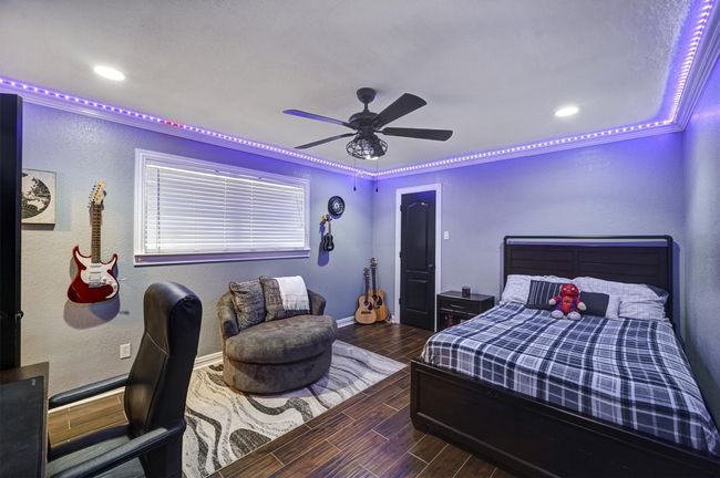 Bedroom with baseboards, a ceiling fan, a textured wall, recessed lighting, and wood finish floors | Image 21