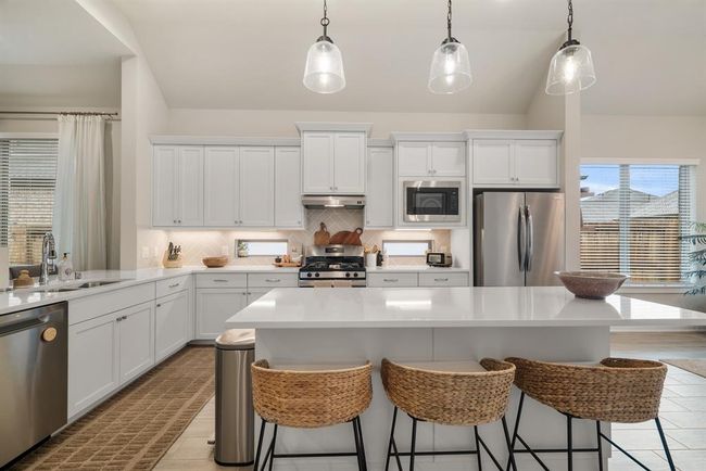 Island with seating and trendy pendant lighting. | Image 10