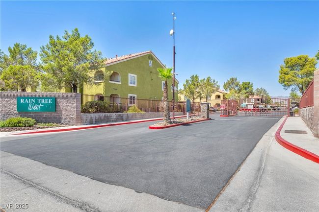 View of street with a gated entry, curbs, sidewalks, and a gate | Image 7