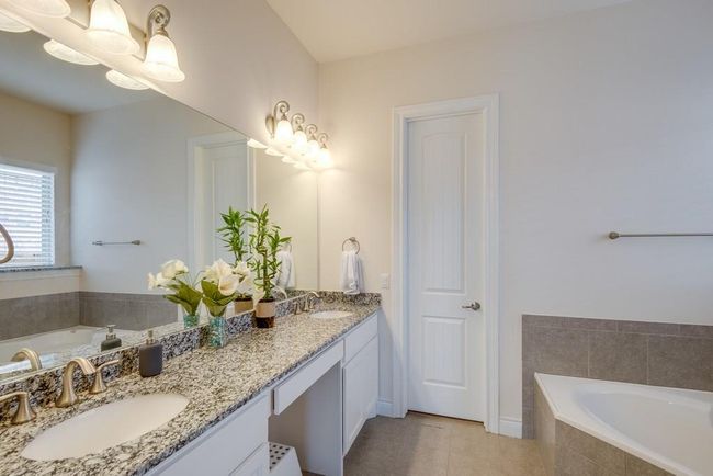 Bathroom with a bath, a sink, and tile patterned flooring | Image 17