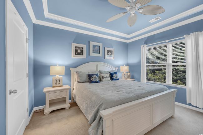 Bedroom with carpet floors, ornamental molding, and ceiling fan | Image 14