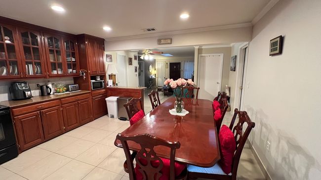 Dining area with ornamental molding, light tile patterned floors, and recessed lighting | Image 4