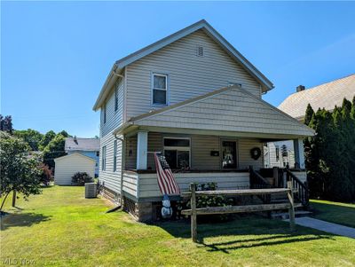 View of front of house featuring a front lawn, a porch, and central air condition unit | Image 1