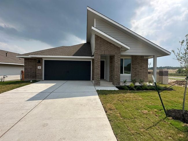 View of front facade with brick siding, an attached garage, a front yard, and driveway | Image 39