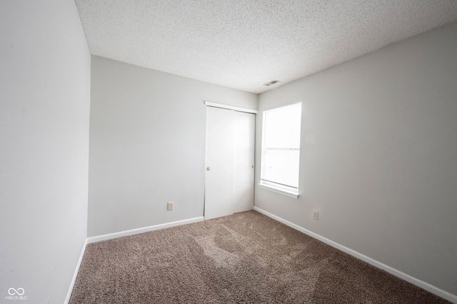 unfurnished bedroom featuring visible vents, carpet floors, a closet, baseboards, and a textured ceiling | Image 39