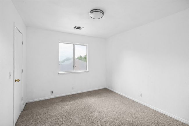 Carpeted empty room with visible vents and baseboards | Image 26