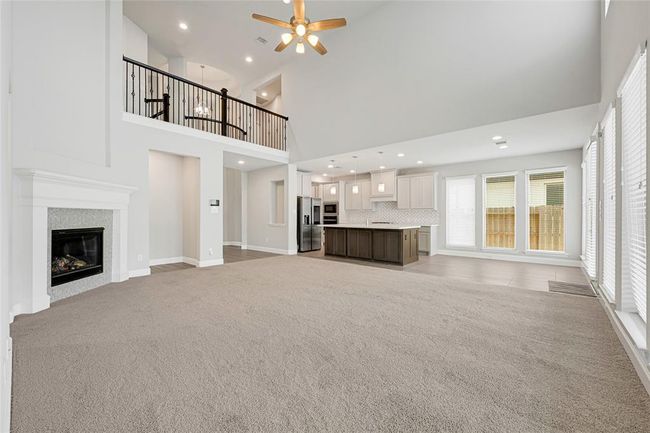 Grand living/family room. High-ceilings, window blinds throughout. Open concept. Cozy fireplace with gorgeous mantel - turns on via remote control. Perfect look for the holidays. | Image 7