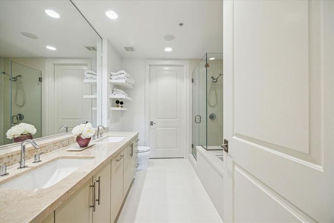The primary bathroom was recently refreshed by a bath and tile restoration company. There are double sinks, a separate tub and shower and plenty of storage room. | Image 18
