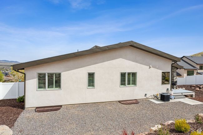 Back of property featuring a patio, central AC unit, stucco siding, and fence | Image 62