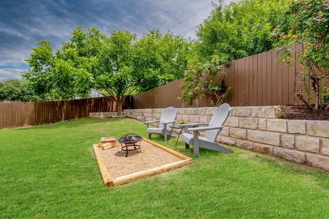 Fenced backyard with an outdoor fire pit | Image 25