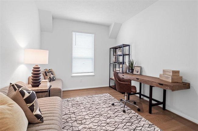 This handsome den features engineered wood flooring, high ceilings, large window with privacy blinds and neutral paint. | Image 9