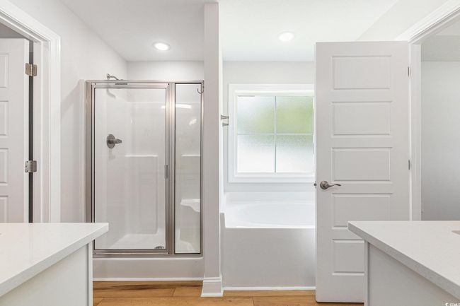 Bathroom with vanity, a shower stall, a bath, and wood finished floors | Image 17