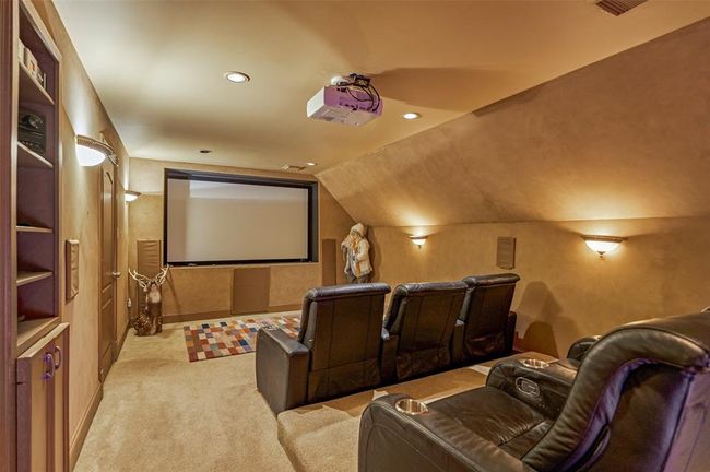 Experience cinematic luxury in this cozy movie room, featuring ambient lighting, six recliners, and a large projector for unforgettable movie nights and sports events. | Image 23