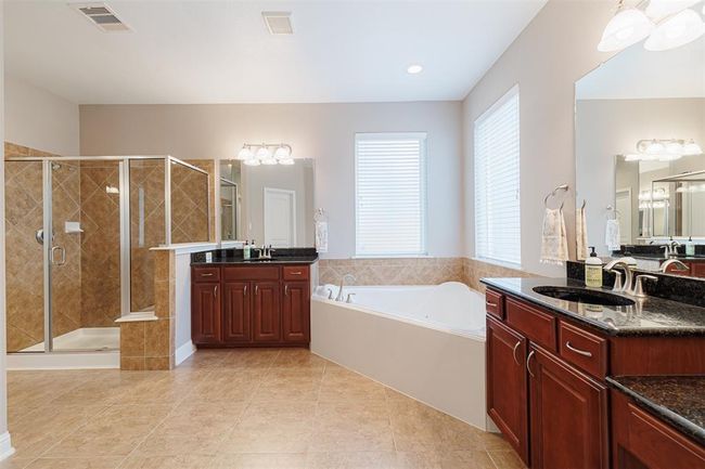 Spa-like primary ensuite bath with double vanities, separate walk-in shower and large jetted tub. | Image 26