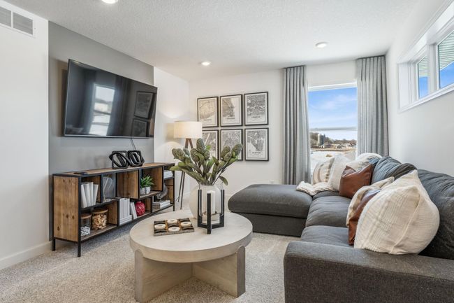 Photo is of the actual model. Located on the upper level, this perfectly sized living space has enough room for a desk, television and seating for all. Plus, it is just steps away from all four upper level bedrooms. | Image 18