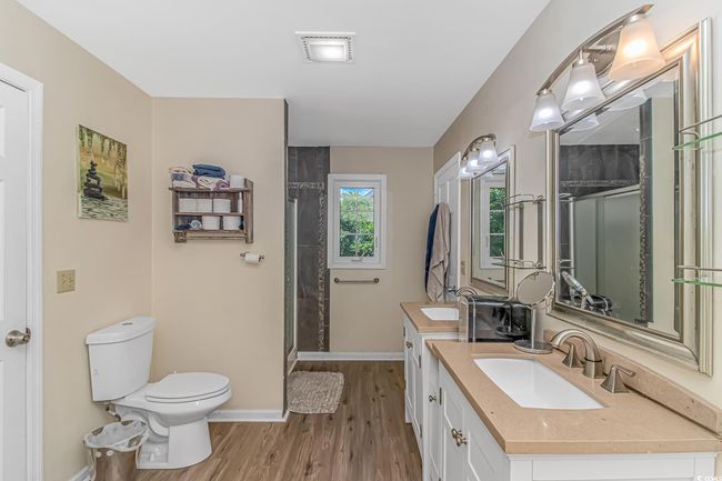Bathroom with vanity, wood finished floors, and a stall shower | Image 16