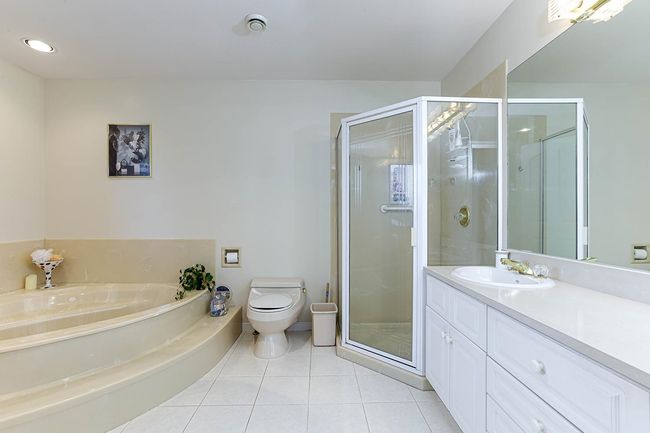 Full bath featuring toilet, tile patterned flooring, vanity, and a shower stall | Image 28